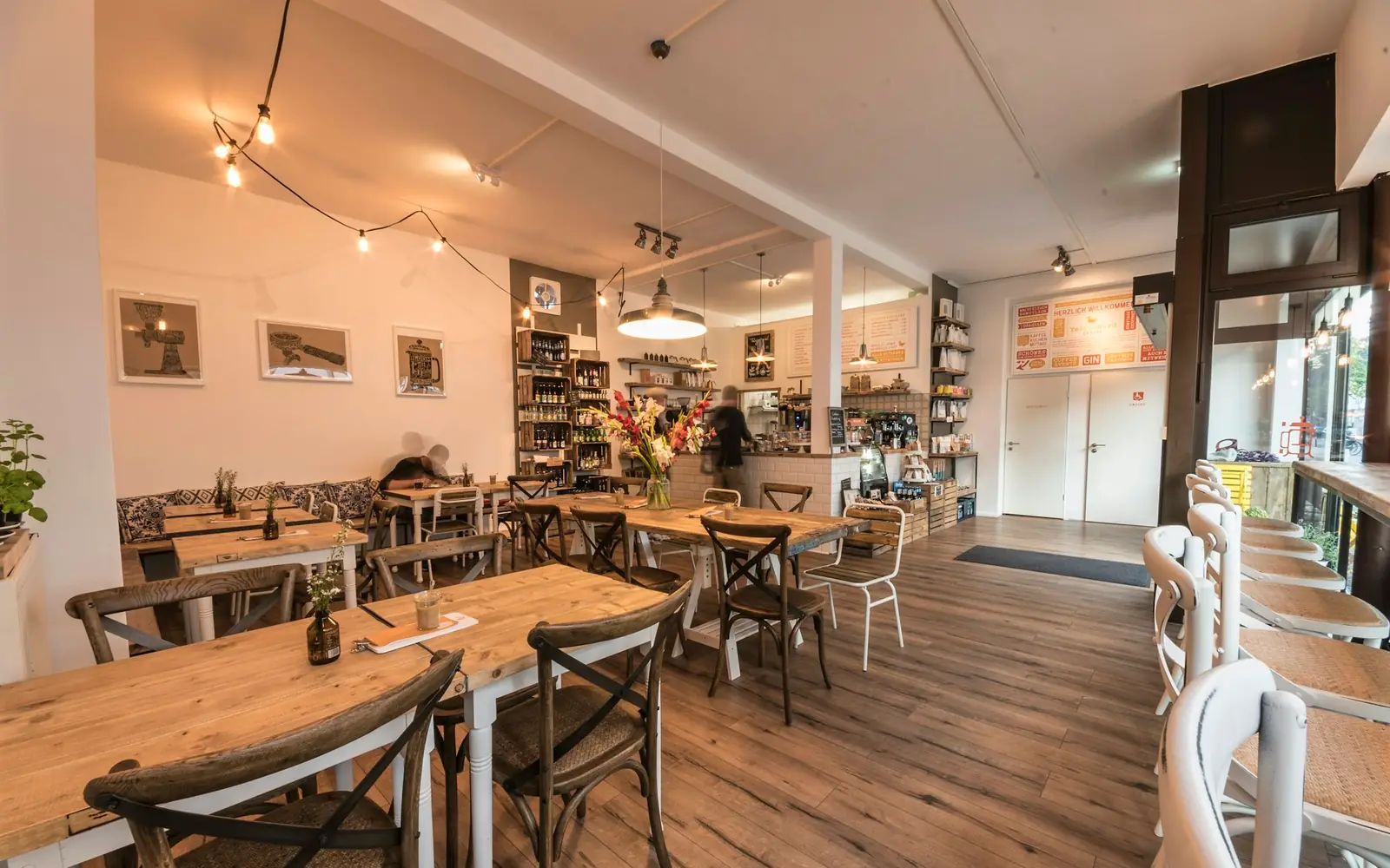 Interior de cafetería reformada con mesas de madera (reforma en Getafe)
